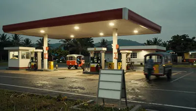 Philippine roadside fuel station at dusk with pump islands, passing jeepney and tricycle, and a blank price board